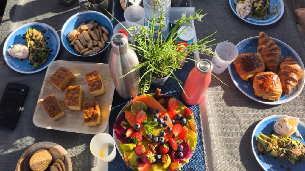 Brunch français servi à bord d’un voilier à Barcelone — fruits frais, viennoiseries et plateaux gourmands